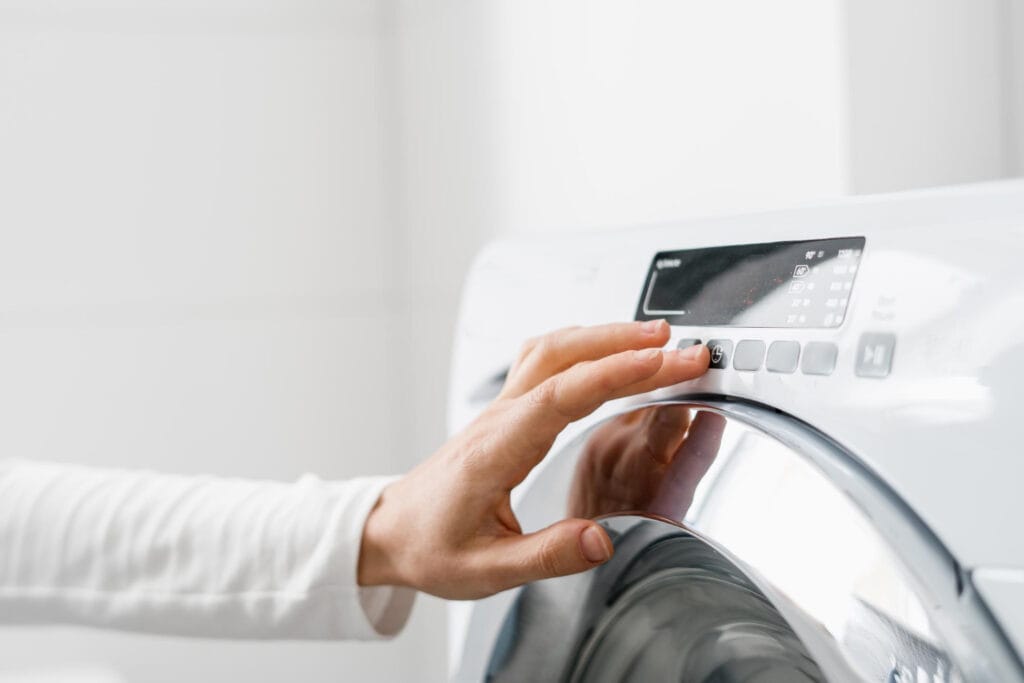 personne qui règle une machine à laver
